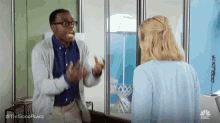 a man and a woman are having a conversation in front of a mirror .