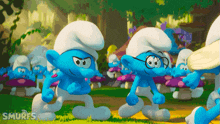 two smurfs standing next to each other with the word smurfs behind them