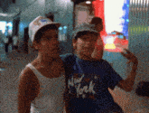 a boy wearing a blue new york shirt stands next to another boy