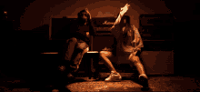 a man and a woman are sitting in front of a marshall amplifier