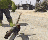 a man is being kicked by a hulk in a video game while standing on the ground .