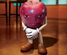a red apple with a face and arms is sitting on a wooden floor