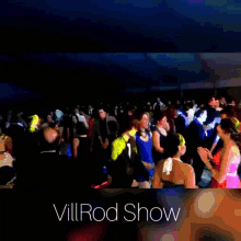 a large crowd of people are gathered in a dark room with the words villrod show written on the bottom