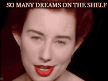 a woman with red hair is smiling with the words so many dreams on the shelf below her