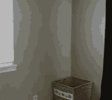 a cat is jumping in a cardboard box with a heart on the wall behind it