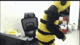 a person in a bee costume is standing next to a chair