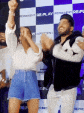 a group of people are dancing in front of a wall that says represent