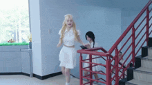 a woman in a white dress is walking down stairs