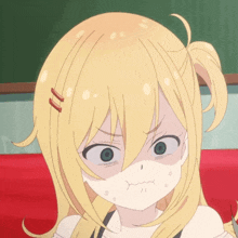 a girl with blonde hair and blue eyes making a funny face