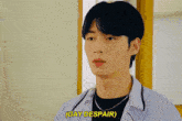a young man in a blue shirt says gay despair in yellow letters
