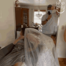 a woman in a wedding dress is covering herself with a veil