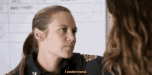a woman in a uniform with the letter h on it talks to another woman