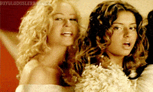 two blonde women are standing next to each other with the words buyuluduslerbangesi written on the bottom right