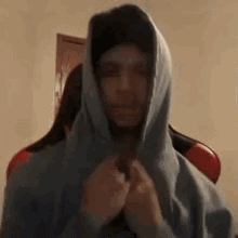 a man wearing a hooded sweatshirt is standing in a room .