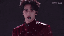 a close up of a man wearing a microphone and a red shirt