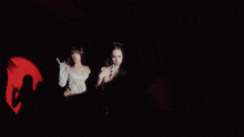 a blurred image of two women standing next to each other in a dark room