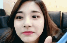 a close up of a woman 's face making a funny face while holding a phone .