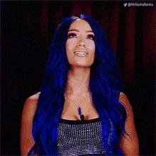 a woman with blue hair and a ring on her finger