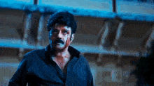 a man with blood on his face is standing in front of a building .