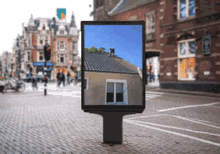 a billboard with a picture of a house on it in a city
