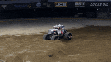 a monster truck is driving on a dirt track in front of a walmart sign