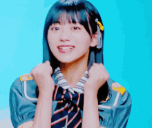 a girl in a striped shirt and tie holds her fists up