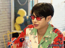 a man wearing red sunglasses and a green shirt has the name judichleh702 on the bottom right