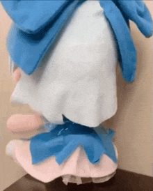 a stuffed animal with a blue scarf around its neck is sitting on top of a table .