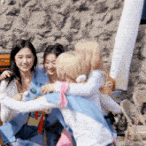 a group of girls are hugging each other with one wearing a shirt that says ' a ' on it