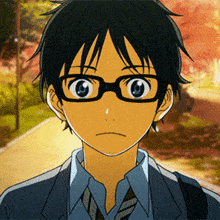 a boy wearing glasses and a blue shirt looks at the camera