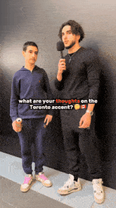 a man holding a microphone stands next to a boy with a can of soda