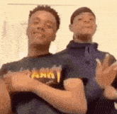 two young men are standing next to each other making funny faces .