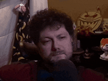 a man with a beard is sitting in front of a stuffed animal