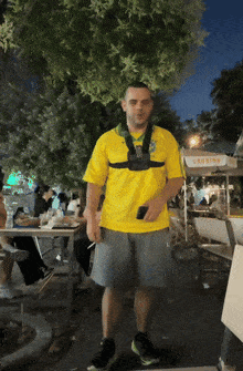 a man in a yellow shirt stands in front of a sign that says crossing