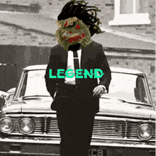 a man in a suit and tie stands in front of a car that says legend on it