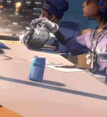 a person in a purple jersey holds an owl over a can of soda