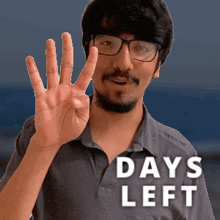 a man wearing glasses and a shirt that says days left shows his hand