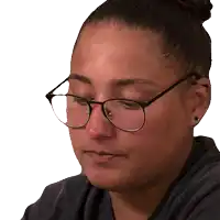 a close up of a woman wearing glasses with a bun in her hair