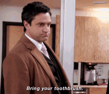 a man in a suit and tie is saying " bring your toothbrush "