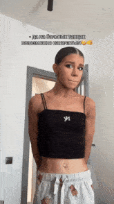 a woman wearing a black tank top with the letter m on the front