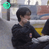 a boy is sitting on a bean bag chair with the words " newkids i want to debut with " on the screen