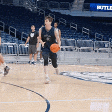 a man wearing a butler jersey dribbles a basketball