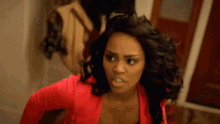 a woman in a red shirt is making a face