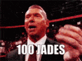 a man in a suit and tie is giving a speech in a wrestling ring .