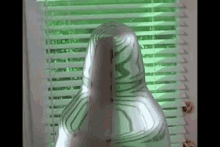 a person is wrapped in duct tape and standing in front of a window with blinds .
