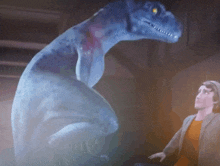 a blue dinosaur is standing next to a man in a room
