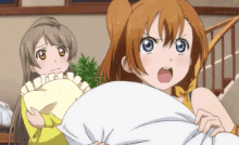 two anime girls are holding a pillow in their hands and one has a surprised look on her face