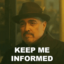a man wearing a hat says " keep me informed " in white letters