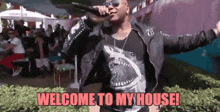 a man is singing into a microphone with the words welcome to my house written below him