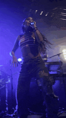a woman singing into a microphone on stage